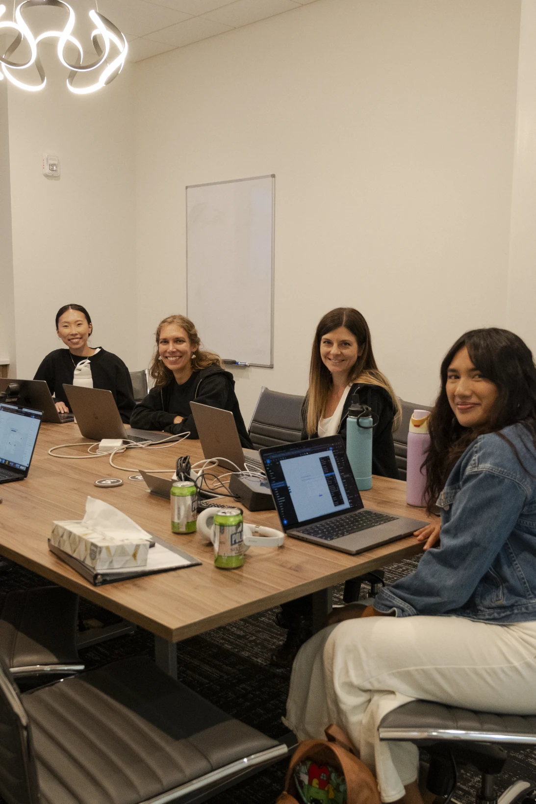 Colleagues working together around a table with laptops